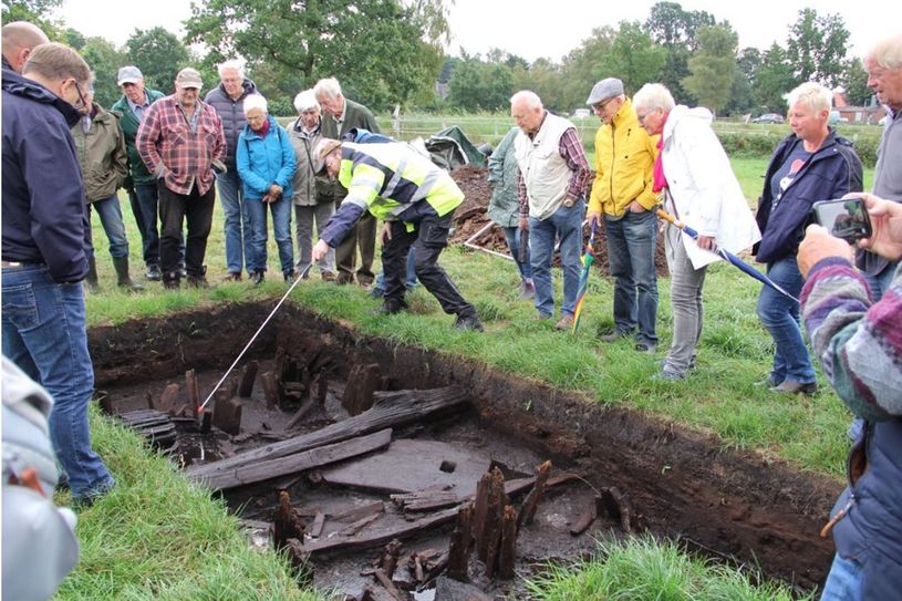 2.000 Jahre alte Spuren menschlichen Wirkens: Kreisarchäologe Dr. Stefan Hesse  (Mitte) präsentiert hier interessierten Mitbürgerinnen und Mitbürgern gefundene Überreste eines alten Bohlenweges, der zur Zeit Christi Geburt eine sichere Passage durch das Moor ermöglichte.  Foto: ue