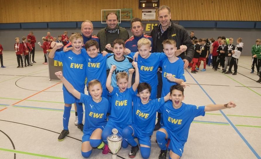 Die Kicker der JSG Ramesloh/Maschen gingen als Sieger beim EWE-Wintercup in Oerel hervor und qualifizierten sich damit für das große Endturnier in Oldenburg. Es gratulierten auch Ex-NationalspielerJens Nowotny und EWE-Regionallieter Rolf Wellbrock. Foto: eb