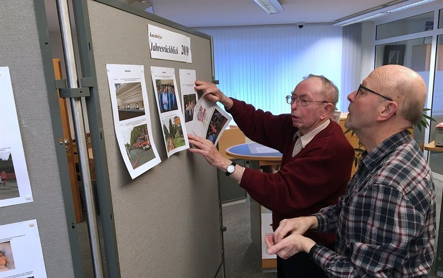 Dorfchronist Heinz Hauschild und Gerd Tessmann (r.) stellen den bebilderten Jahresrückblick im Empfang der Geschäftsstelle der Kreissparkasse in Kutenholz zusammen. Foto: eb