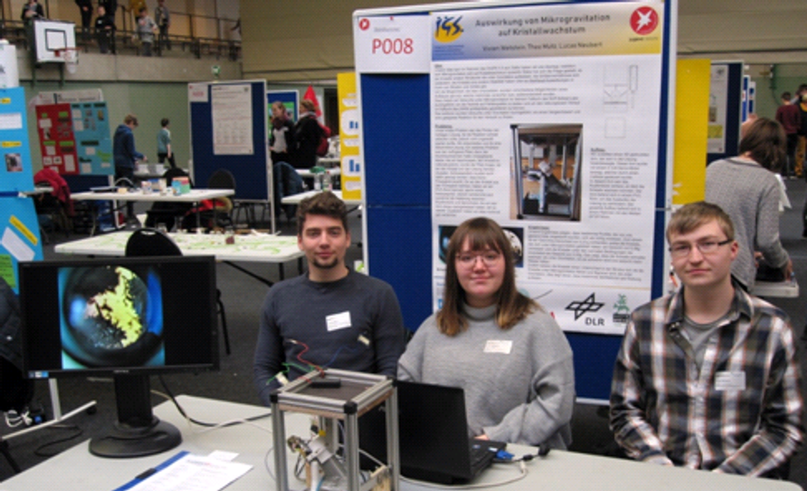 Theo Mutz, Vivien Wetstein und Lucas Neubert am Stand ihres Projektes „Auswirkungen von Mikrogravitation auf Kristallwachstum“, das ihnen den 3. Platz im Fachgebiet Physik einbrachte.  Foto: eb