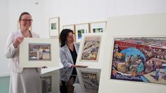 Corinna Facktor von der Fielmann Filiale aus Osterholz-Scharmbeck und Beate Arnold vom Barkenhoff präsentierenn die Plakatenwürfe Heinrich Vogelers aus den 1930er Jahren.   Foto: pvio