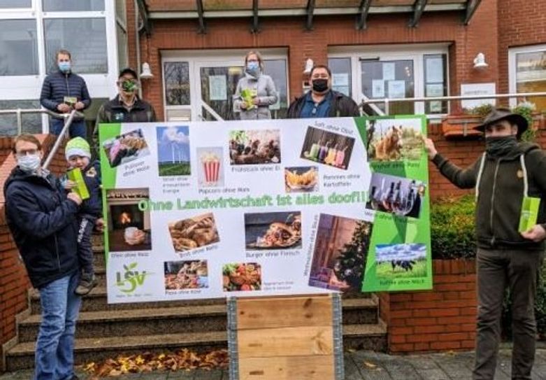 Landwirte überreichten ein Plakat mit der Aufschrift „Ohne Landwirtschaft ist alles doof“ an Bürgermeister Guido Dieckmann und Claudia Lühmann (hinten).  Foto: kh