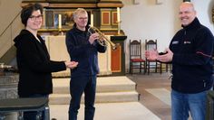 Kantorin Caroline Schneider-Kuhn und Bläser Rüdiger Suckert von der St. Willehadi-Gemeinde überreichen Stefan Bischoff vom Malteser Hilfsdienst die Spende für die Obdachlosenhilfe.
 Foto: Jörn Mangels, Fotoscheune OHZ