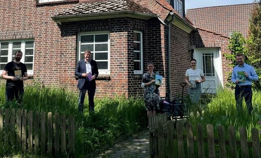 Dirk-Frederik Stelling (v.r), Vanessa Zobel und Oliver Grundmann überreichen Bücher an Sabine Schneider und Stephan Dreytza vor dem neuen Domizil des Nachbarschaftsladens.