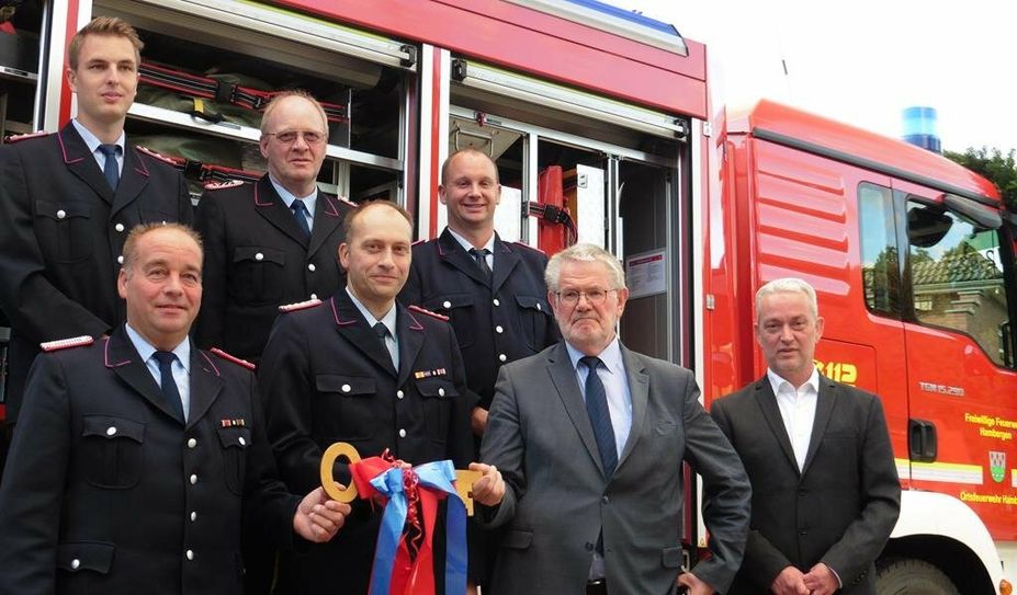 Samtgemeindebürgermeister Reinhard Kock (2. von rechts) übergibt den Rüstwagen symbolisch an Ortsbrandmeister Ralf Peters (unten links). Foto: mf