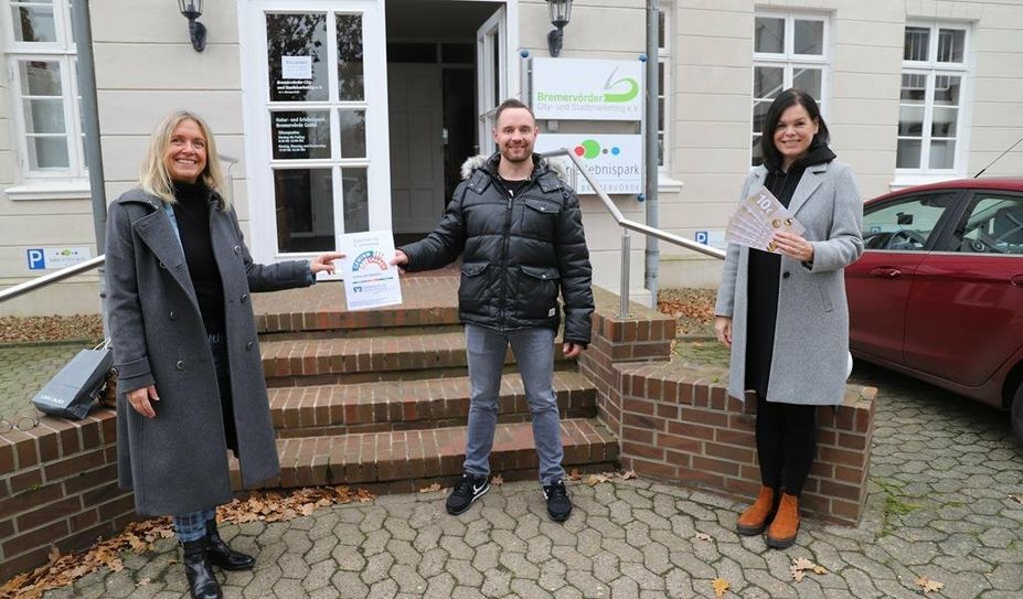 Gerrit Kapke nimmt seinen Gewinn freudestrahlend aus den Händen von Ulrike Schloen und Bärbel Hensel entgegen.