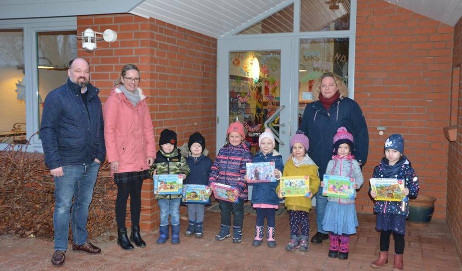 Kita-Leiterin Juliane Dallüge (re.) und die Kita-Kinder freuen sich über die Spende von Timm und Nicole Haberland.