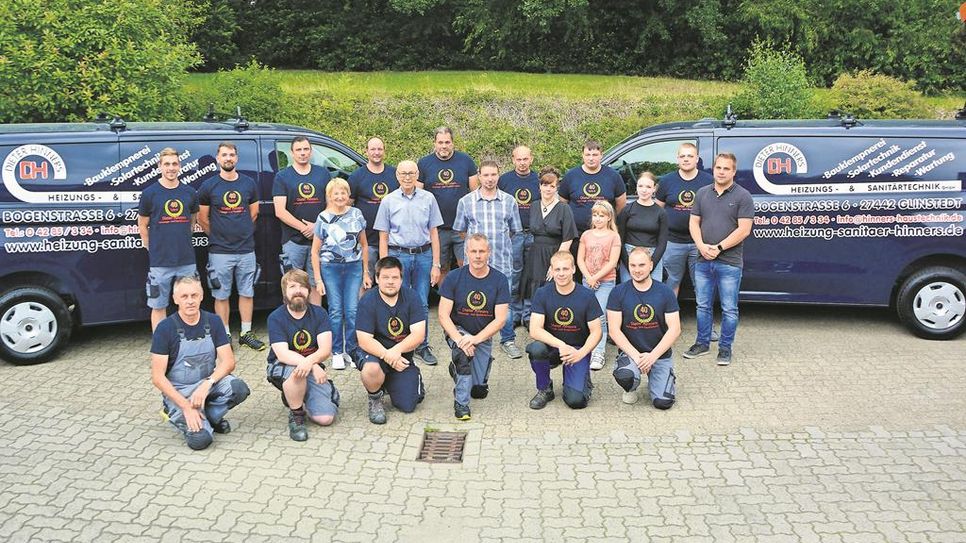 Dieter Hinners (Mitte, 2. v. li.) hat sich fürs Gruppenbild mit seiner Familie und seinen Mitarbeitenden aufgestellt.