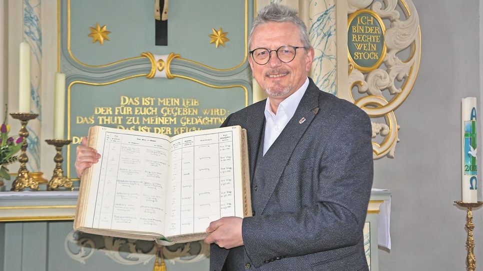 Landrat Bernd Lütjen (Osterholz) zeigt das Kirchenbuch der St. Cosmae und Damiani-Kirche in Hambergen, in dem die Hochzeit von Helmut und „Loki“ Schmidt am 1. Juli 1942 festgehalten wurde.